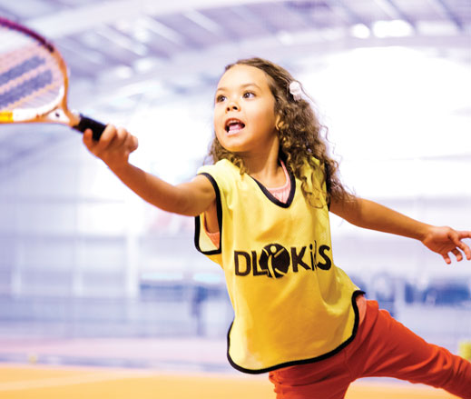 Image of girl hitting tennis ball