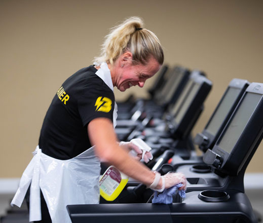 Image of lady cleaning treadmill